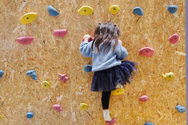 ボルダリングで遊ぶ女の子