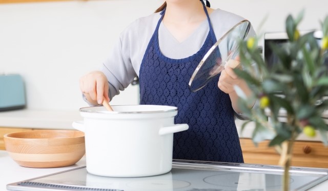 エプロンをしてキッチンに立っている女性