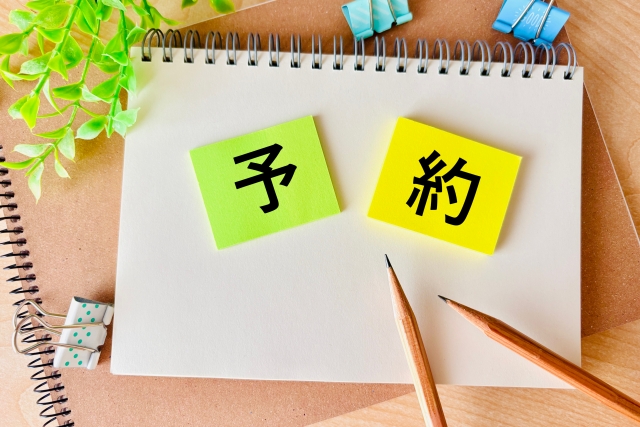 スケッチブックの上にある予約と書かれた付箋