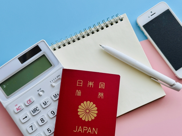 メモ帳とペン、電卓とパスポートが置いてある