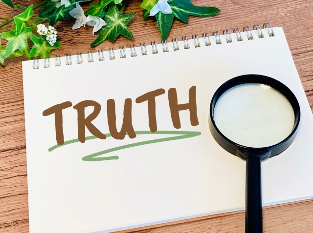 虫眼鏡とスケッチブックにtruthの文字が書かれている