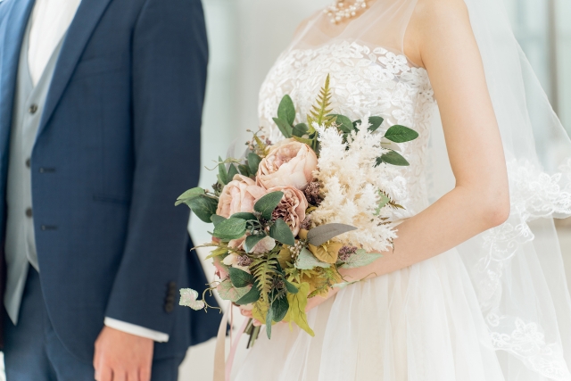 ブーケを持つ新婦と手をつなぐ新郎
