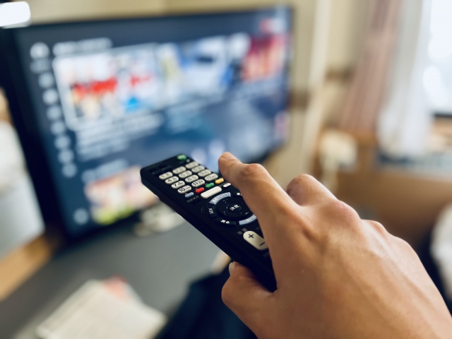 リモコンでテレビのチャンネルを変えている