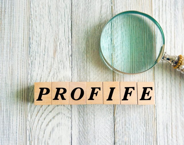PROFILEと書かれた木と置かれた虫眼鏡