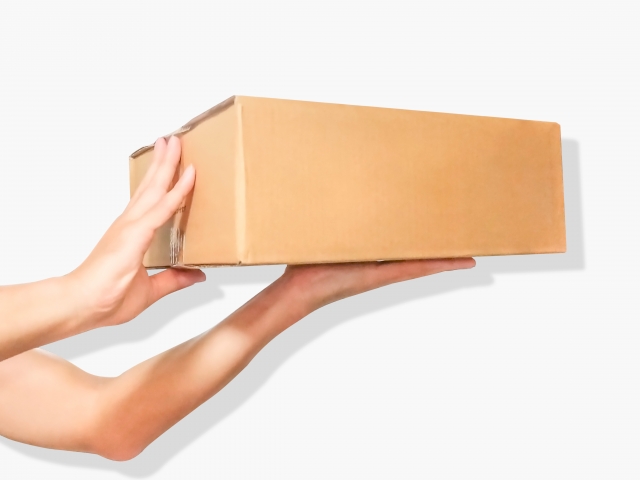 段ボールを持ち上げる手