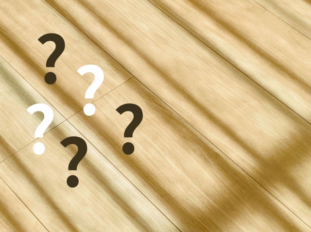 光が差し込んでいる木のテーブルにはてなマーク