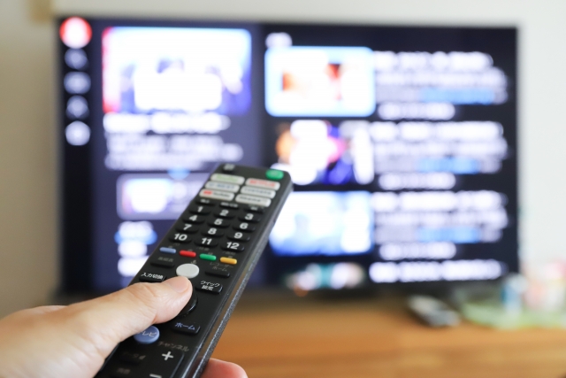 動画配信サービスをリモコンで付けている手