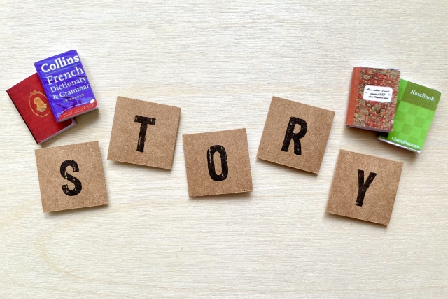 storyと書いた積み木の周りにほんのミニチュア模型